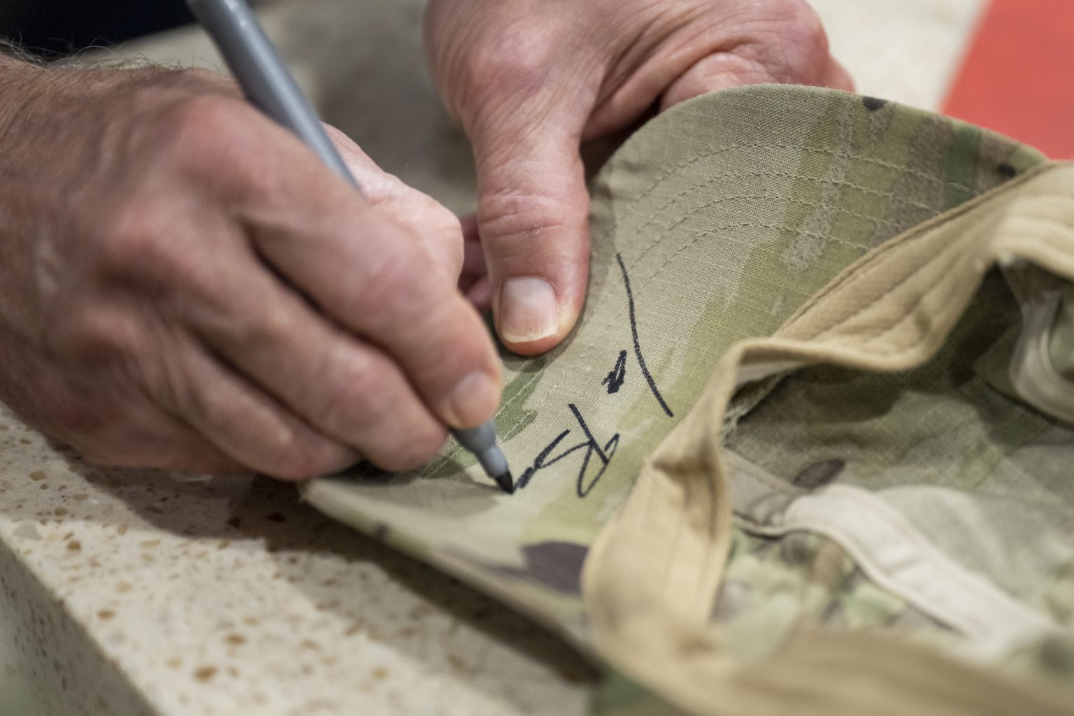 President Joe Biden signs a cap during a meet and greet with members of the U.S. Air Force 51st Fighter Wing, U.S. Forces Korea and their families, Sunday, May 22, 2022, at the MiG Alley Bowling Center at Osan Air Base in Seoul, South Korea. (Official White House Photo by Adam Schultz)